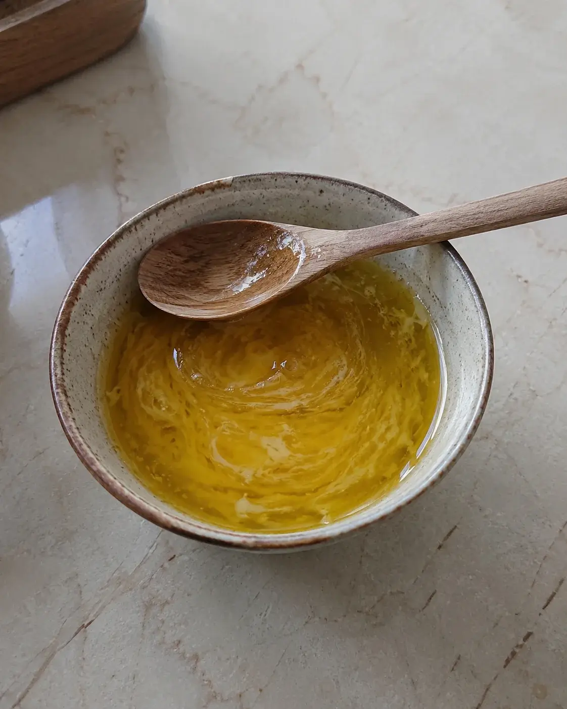 Keramička činijica sa mešavinom ulja, meda i žumanceta